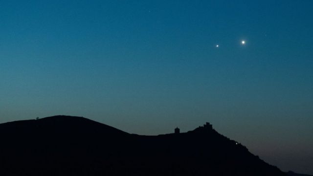 Jupiter and Venus rise before sunrise on April 30, 2022 behind the Italian fort of Roca Galacio